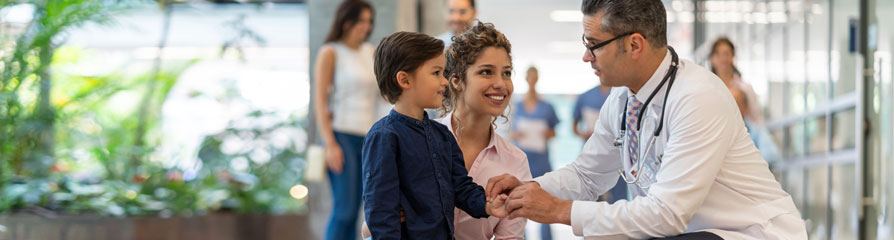 Pediatrician with young boy and Mom