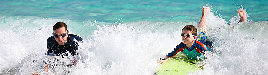 Father and son surfing in the ocean